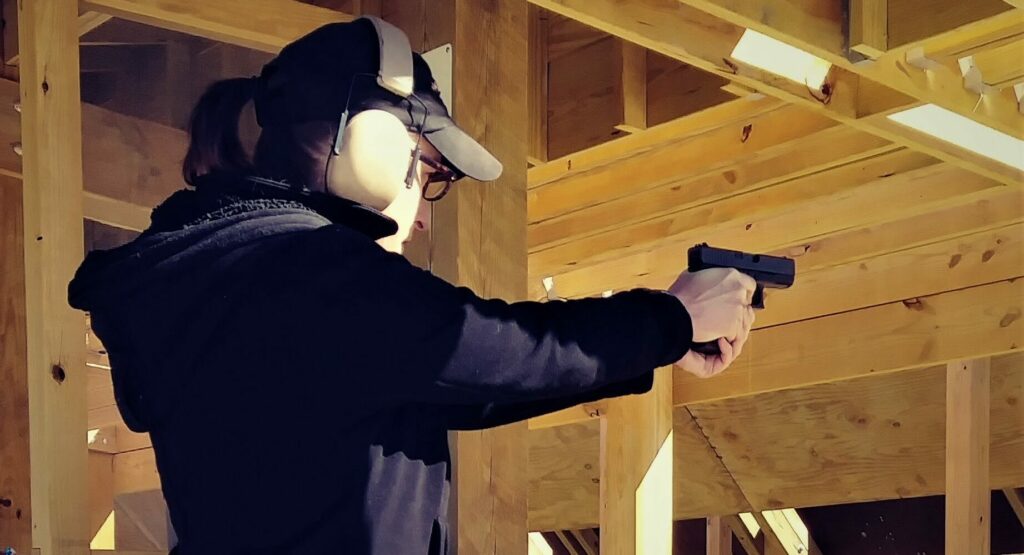 The author firing a pistol at the shooting range.