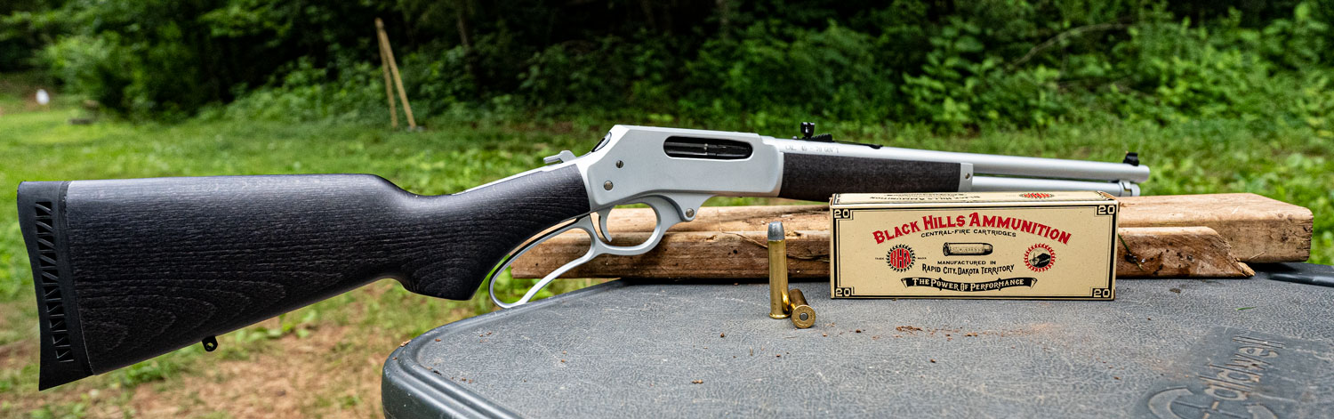 45-70 lever action rifle with ammo on a shooting bench