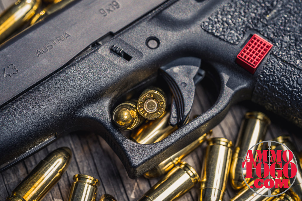 photo of a glock 43 pistol with 9mm fiocchi ammo on plywood