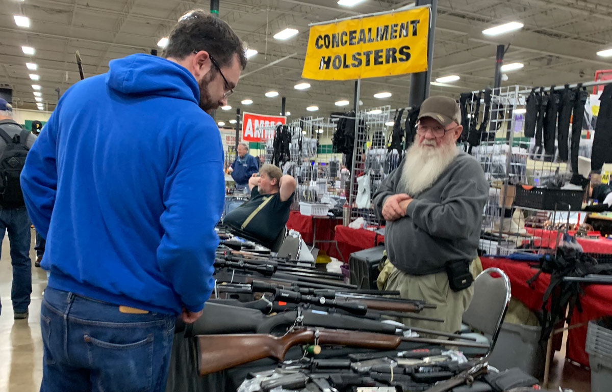 man considering a gun purchase at a gun show