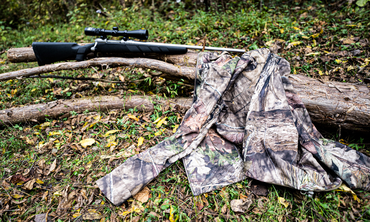 scent control hunting jacket and rifle in the woods