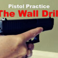 a pistol demonstrating the wall drill in a home