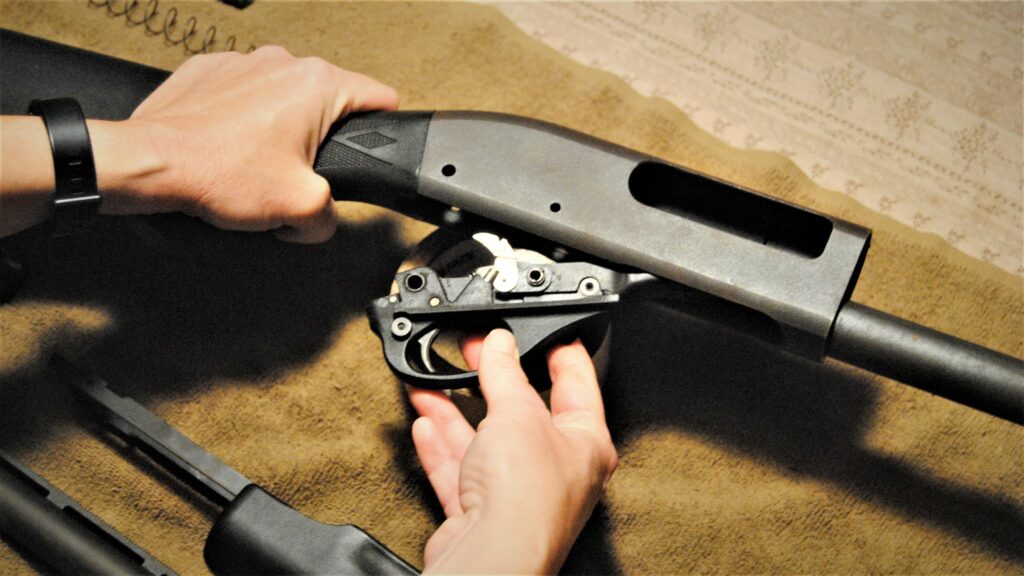 Removing the trigger group in order to clean the chamber area of the shotgun